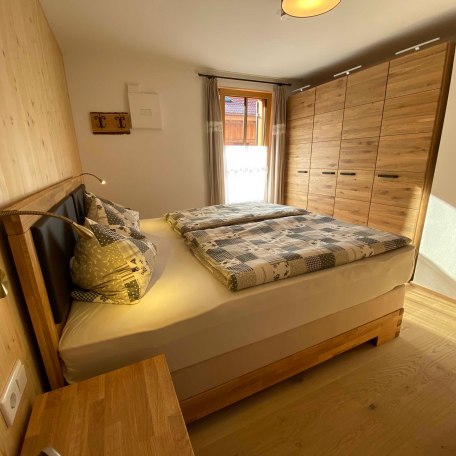 Da weckt die Sonne - Schlafzimmer zum Ostbalkon mit großem Kleiderschrank aus massiver Eiche, © im-web.de/ Tourist-Information Bayrischzell